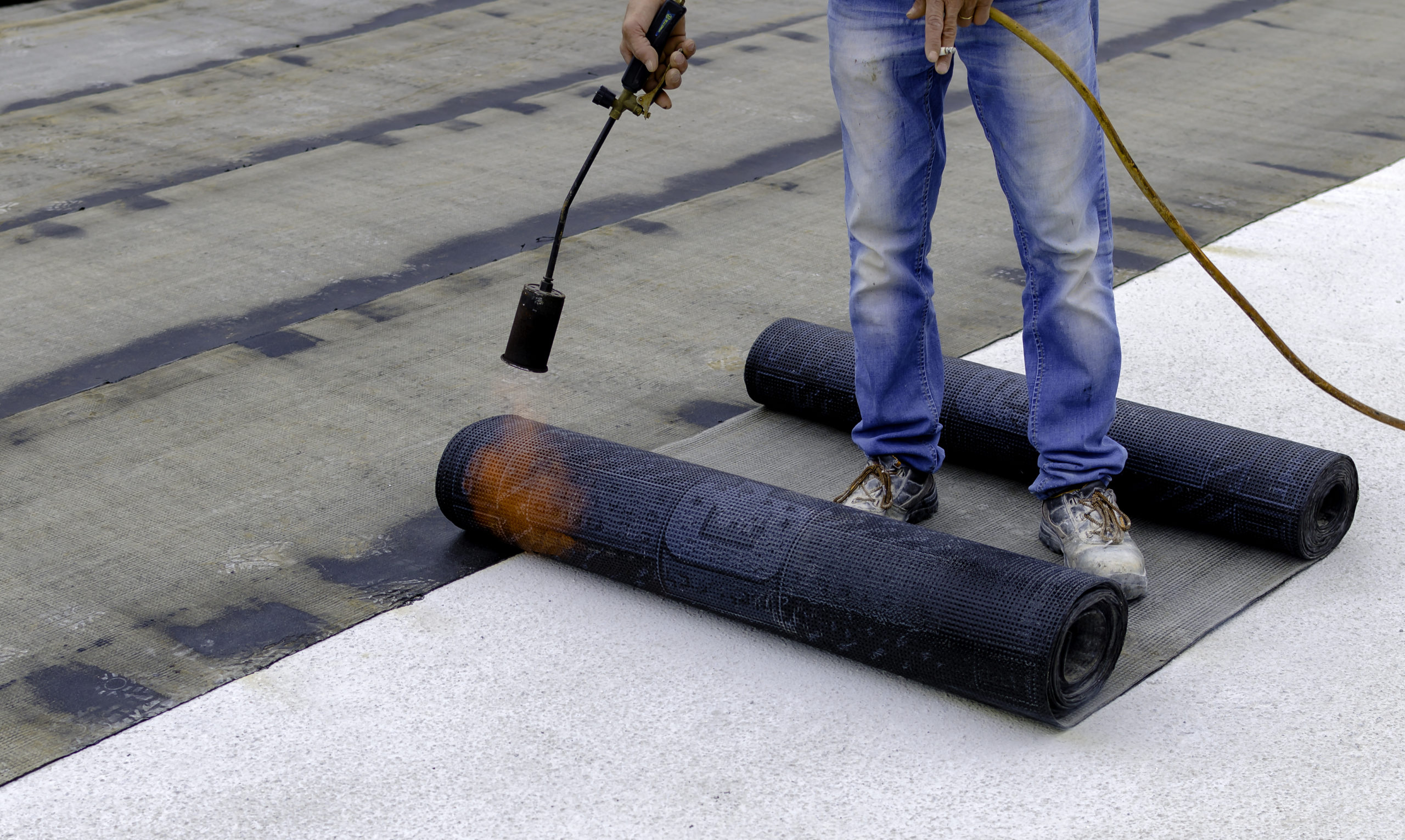 Roofer,Installing,Rolls,Of,Bituminous,Waterproofing,Membrane,For,The